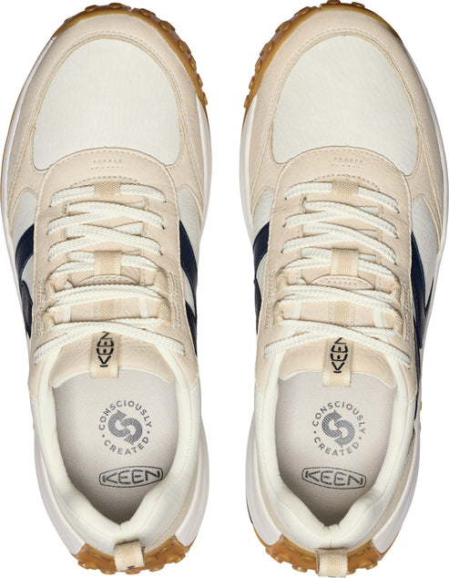 Top-down view of two off-white sneakers with navy blue side stripes, off-white laces, white soles, and brown rubber outsoles. "KEEN" and a circular icon with "CONSCIOUSLY CREATED" are visible on the insole.