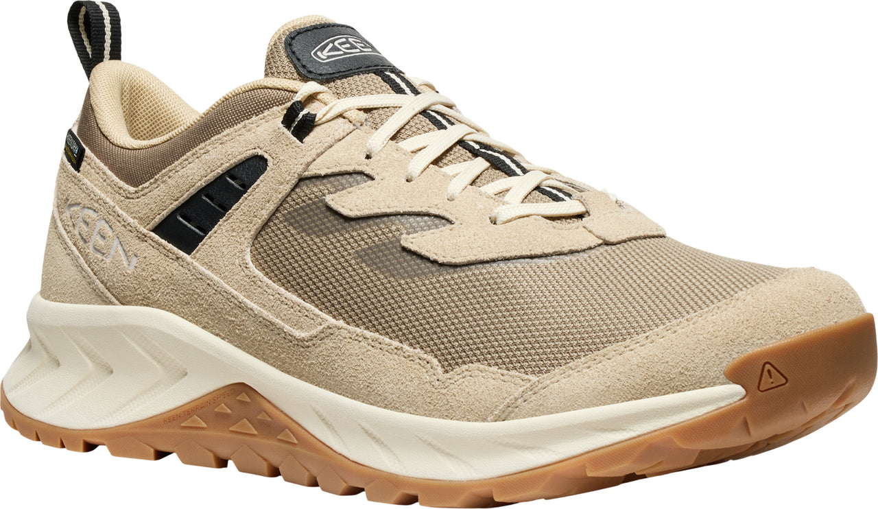 Beige running shoe with suede accents, rubber sole, and black pull tab.