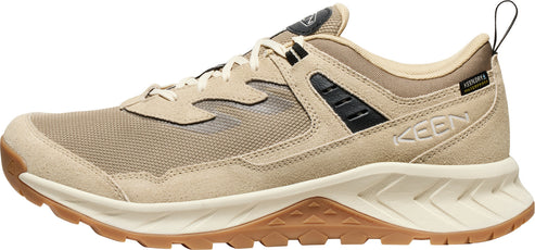 A tan-colored low-top hiking shoe with brown soles and black accents.