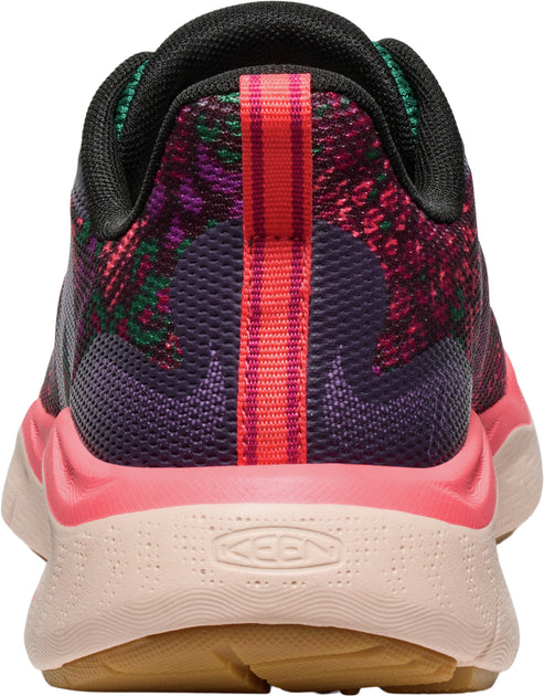 The back of a sneaker with a salmon pink and tan textured sole, a bright pink heel, a purple mesh heel cup, and a floral patterned upper.