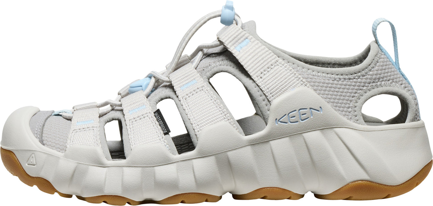 A gray sandal with an open design and brown soles.