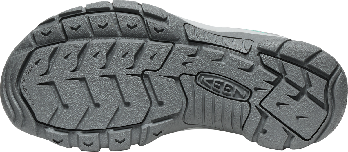 A gray shoe sole with deep treads.