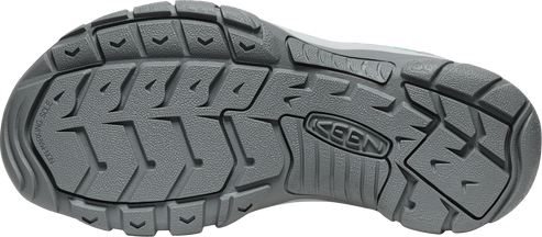 A gray shoe sole with deep treads.