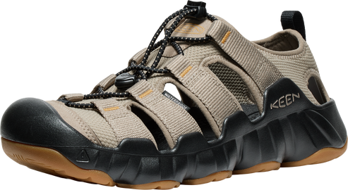 Beige sandal with a dark toe cap, open design, black sole, and bungee lacing system.