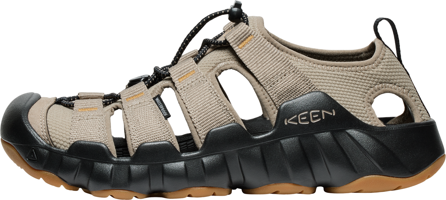 A Keen sandal with a taupe upper and black and brown sole.