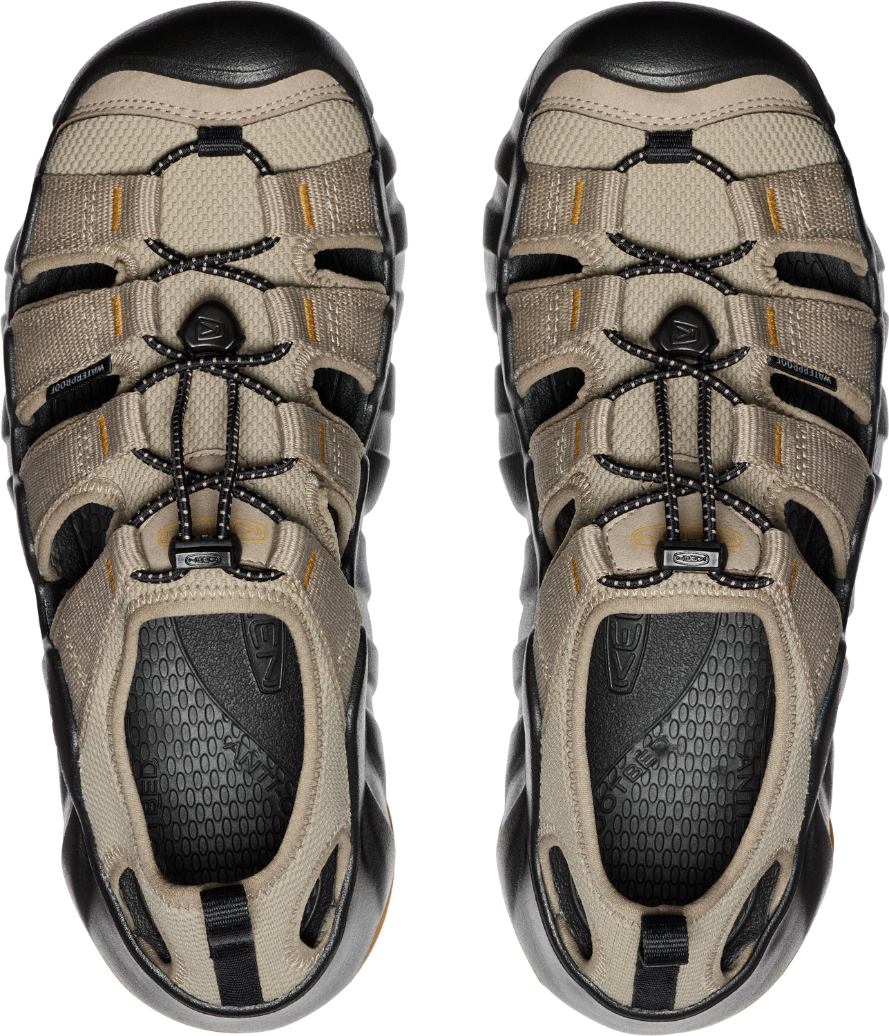 Overhead view of two beige sandals with black soles and bungee cord laces.