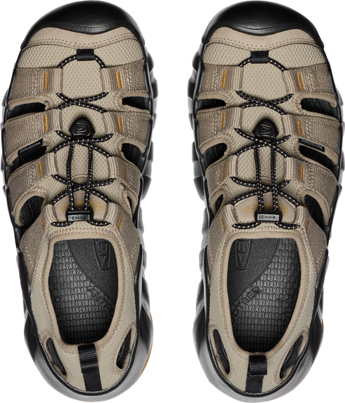 Overhead view of two beige sandals with black soles and bungee cord laces.