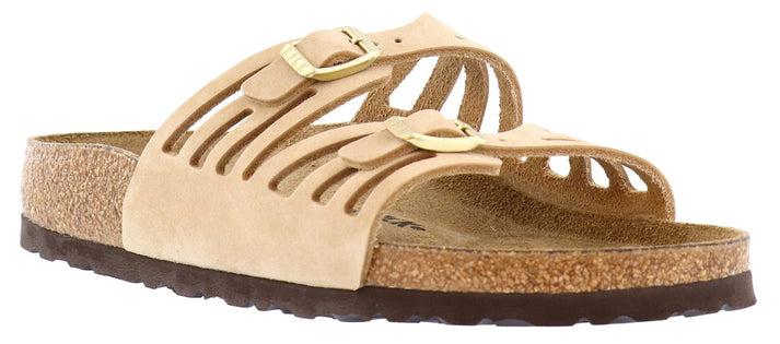 Sandals with a beige cork footbed and matching straps, featuring two gold buckles.