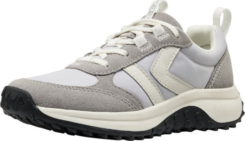 A low-top sneaker with white and gray panels, a jagged black sole, and white laces.