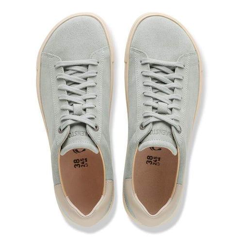Top-down view of a pair of suede sneakers in light blue with white laces and tan soles and lining.