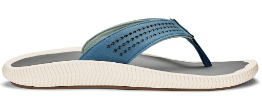 A blue sandal with small holes and a white sole.