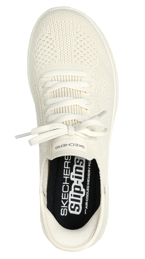 Top-down view of a cream-colored shoe with laces and visible insole labeled "SKECHERS Slip-ins" and "Air Cooled Memory Foam".