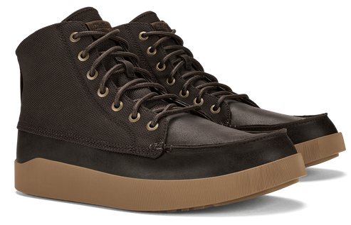 Ankle height boot with brown leather toe and black canvas top on brown sole.