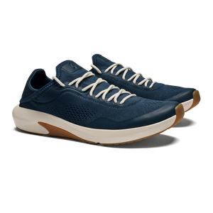 A pair of navy blue athletic sneakers with cream-colored laces and a white midsole with a gum rubber outsole, viewed from a three-quarter angle.