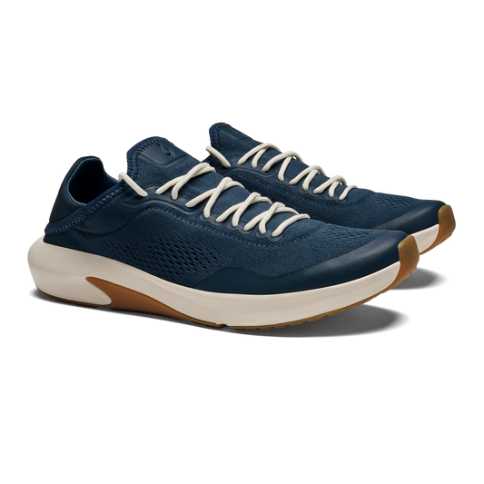 A pair of navy blue athletic sneakers with cream-colored laces and a white midsole with a gum rubber outsole, viewed from a three-quarter angle.