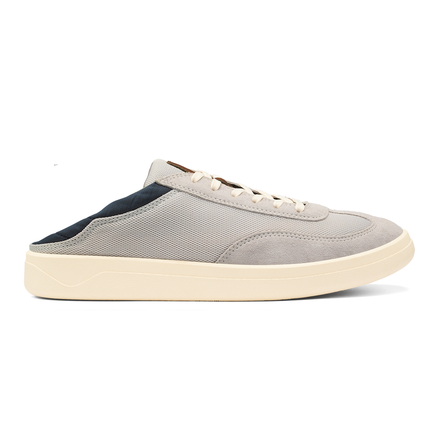 A light grey slip-on sneaker with a dark navy heel collar, white laces, and a thick cream-colored rubber sole against a plain background.