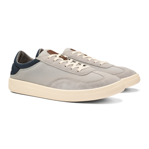 A pair of low-top sneakers in light gray suede and mesh with off-white midsoles, white laces, and navy blue heel accents.