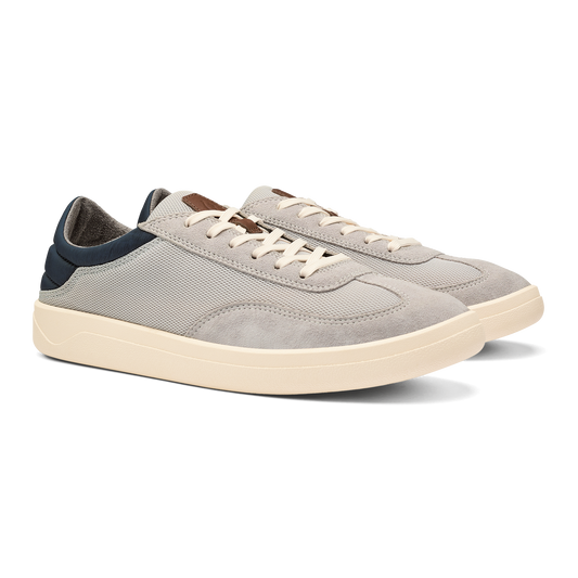 A pair of low-top sneakers in light gray suede and mesh with off-white midsoles, white laces, and navy blue heel accents.