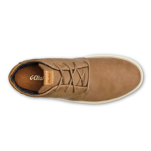 A top-down view of a tan leather casual sneaker with a white rubber sole, featuring brown laces and a light brown tongue label with the word OluKai printed on it.