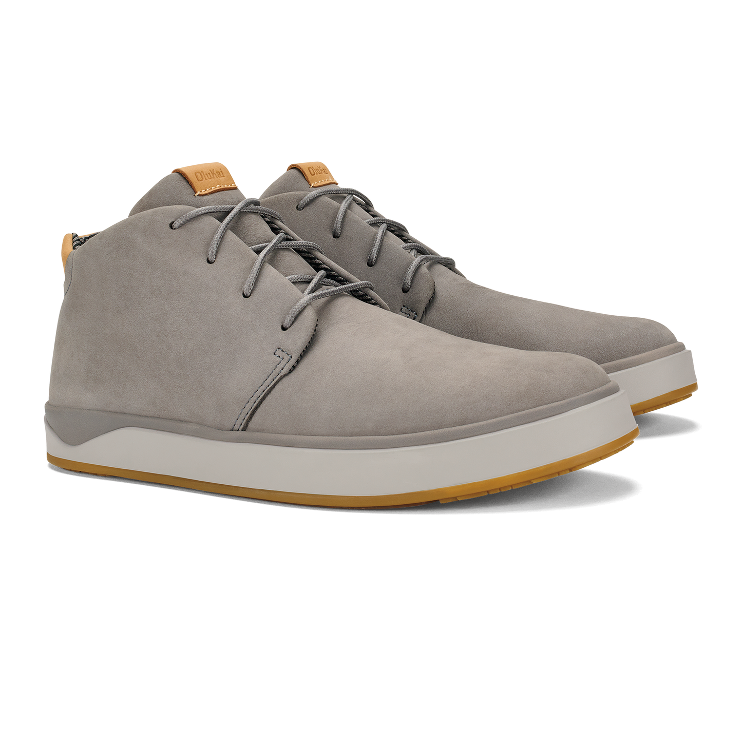 A pair of grey suede lace-up chukka-style sneakers with a thick white midsole and a gum-colored rubber outsole, featuring tan leather tongue tabs.