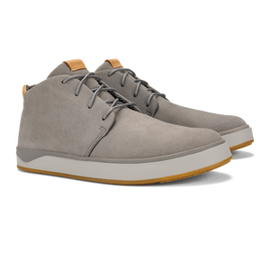 A pair of grey suede lace-up chukka-style sneakers with a thick white midsole and a gum-colored rubber outsole, featuring tan leather tongue tabs.