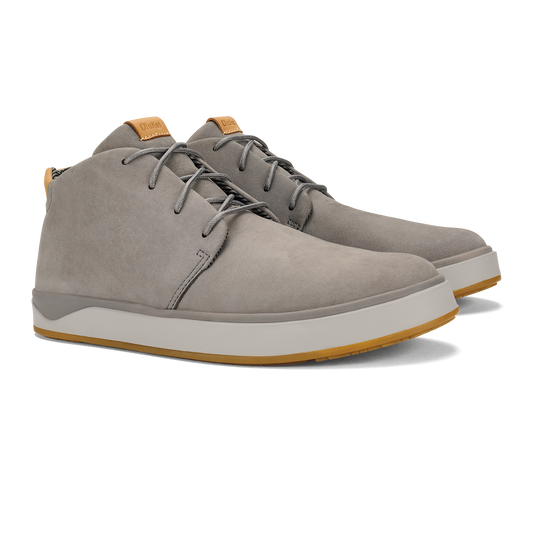 A pair of grey suede lace-up chukka-style sneakers with a thick white midsole and a gum-colored rubber outsole, featuring tan leather tongue tabs.