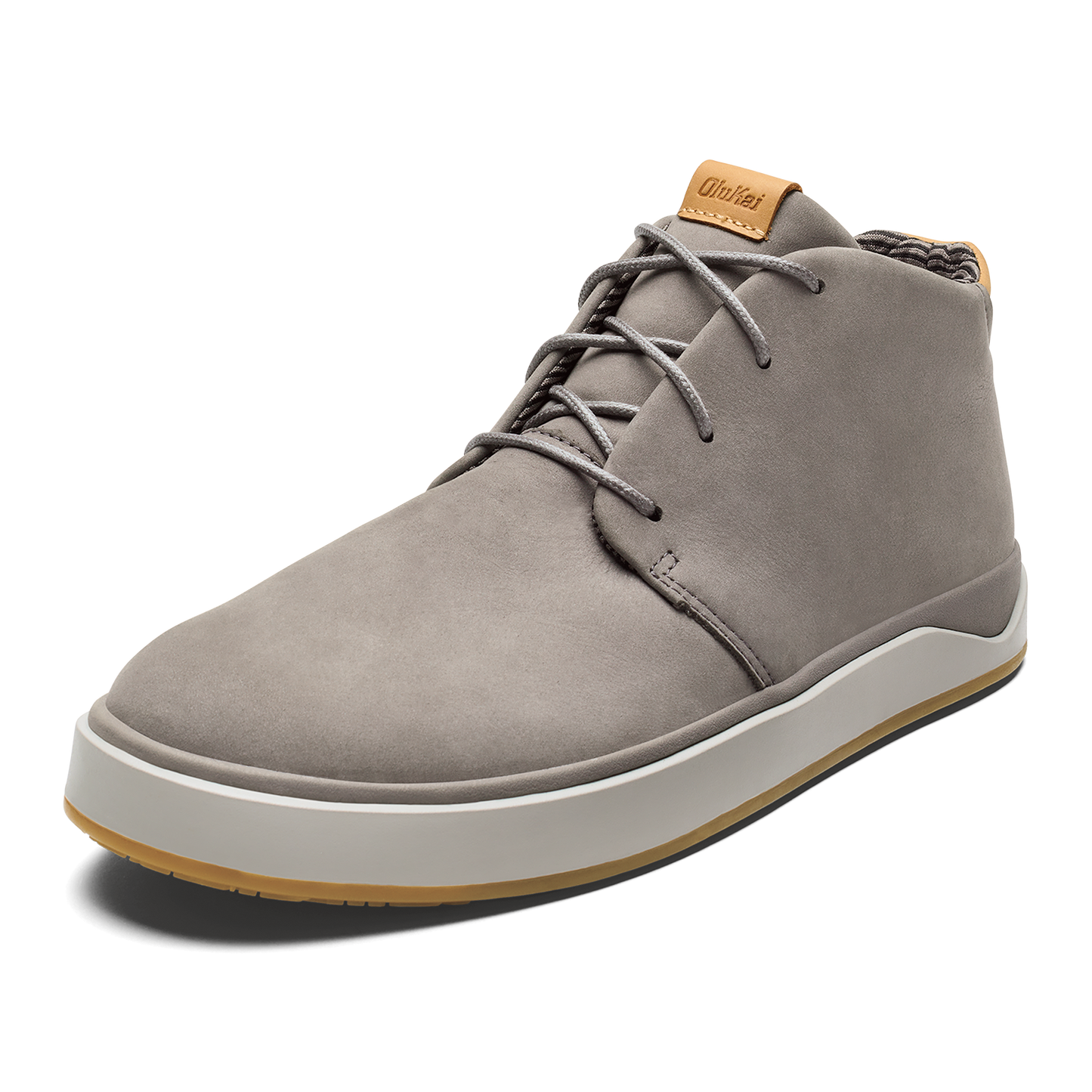 A gray leather chukka-style sneaker with a white midsole, brown gum outsole, and light brown label on the tongue with the text OluKai.