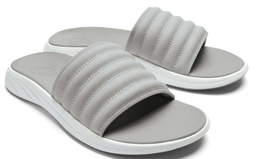 Pair of gray slide sandals with a thick quilted strap and white sole.