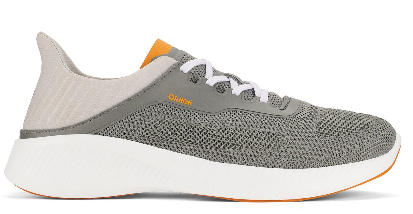 Gray athletic shoe with white sole, white laces, and orange interior lining.