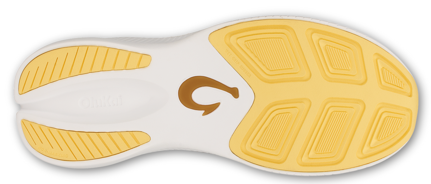 Bottom of a shoe with a tan logo in the middle and yellow treads.