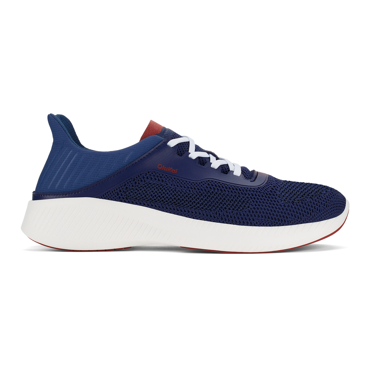 A navy blue low-top athletic sneaker with a thick white midsole, white laces, and a small reddish-brown accent on the heel and near the laces, viewed from the side.