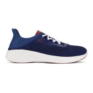 A navy blue low-top athletic sneaker with a thick white midsole, white laces, and a small reddish-brown accent on the heel and near the laces, viewed from the side.