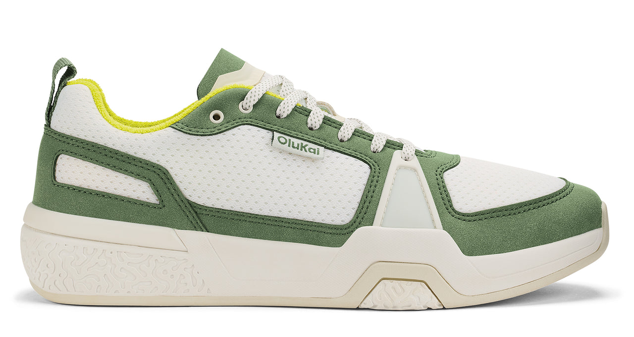 Low top white and green sneaker with logo.