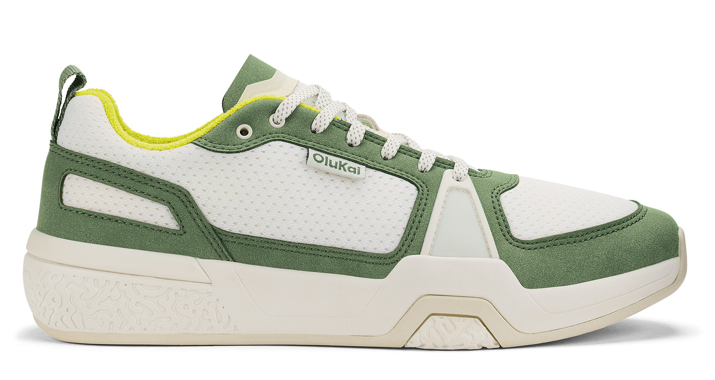 Low top white and green sneaker with logo.