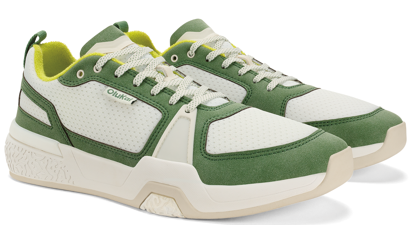A pair of olive green and white athletic shoes with white laces and yellow lining.
