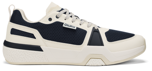 A low-rise sneaker in dark blue and cream with white laces.