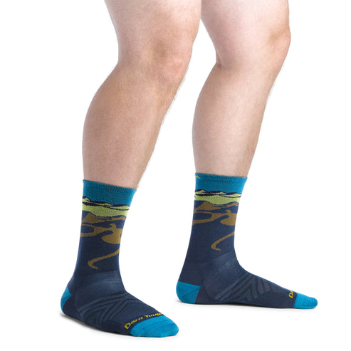 Person wearing calf-length socks with an abstract mountain scene.