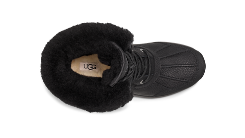 Top-down view of a black boot with black fur trim and a white sole.