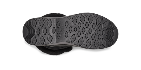 The underside of a boot, showing the sole with its diamond-shaped treads and an embossed logo. The edge of the boot features a fluffy, white material.