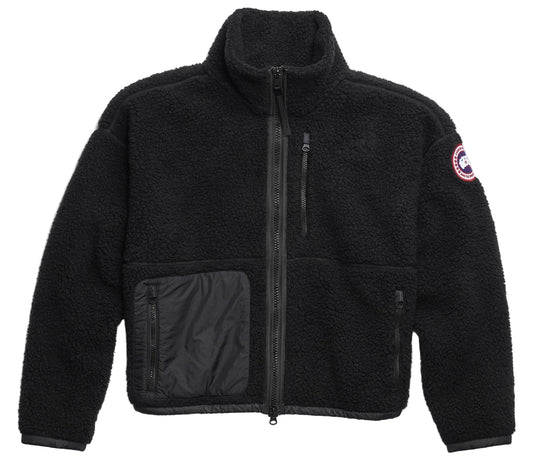Black fleece jacket with full zip, chest zip pocket, side pocket, and circular patch on the sleeve.