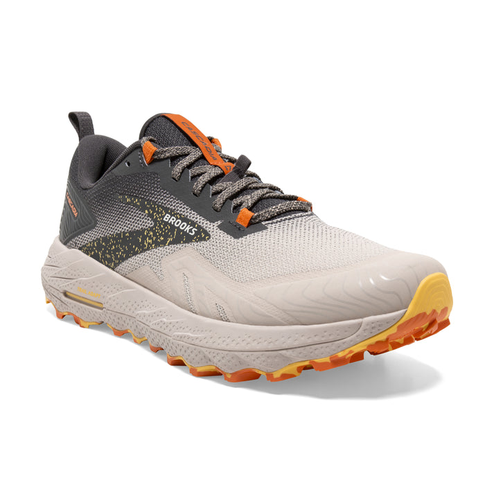 Tan and grey running shoe with orange trim and laces; "BROOKS" printed on the side.