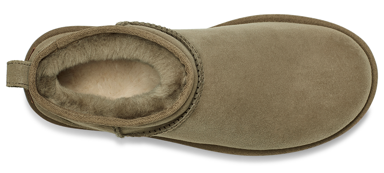 A tan Ugg boot with a tan trim and light-colored fur lining.