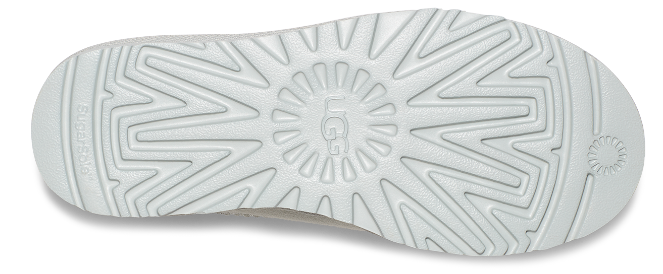 The white sole of a shoe with a star-shaped pattern and "UGG" logo in the center.