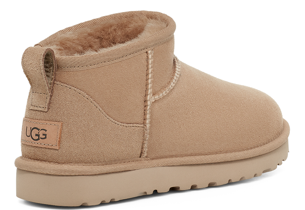 Ankle height, beige UGG boot with a sheepskin lining and loop pull at the back of the heel.