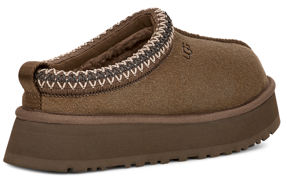 Brown slipper with a thick sole and a decorative trim around the opening.