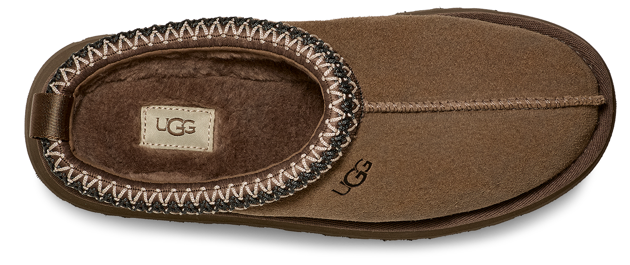 A brown slipper with a decorative trim around the opening and a logo on the side.