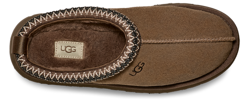 A brown slipper with a decorative trim around the opening and a logo on the side.