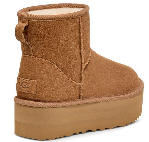 An UGG ankle boot with a tall platform sole and a pull loop on the back.