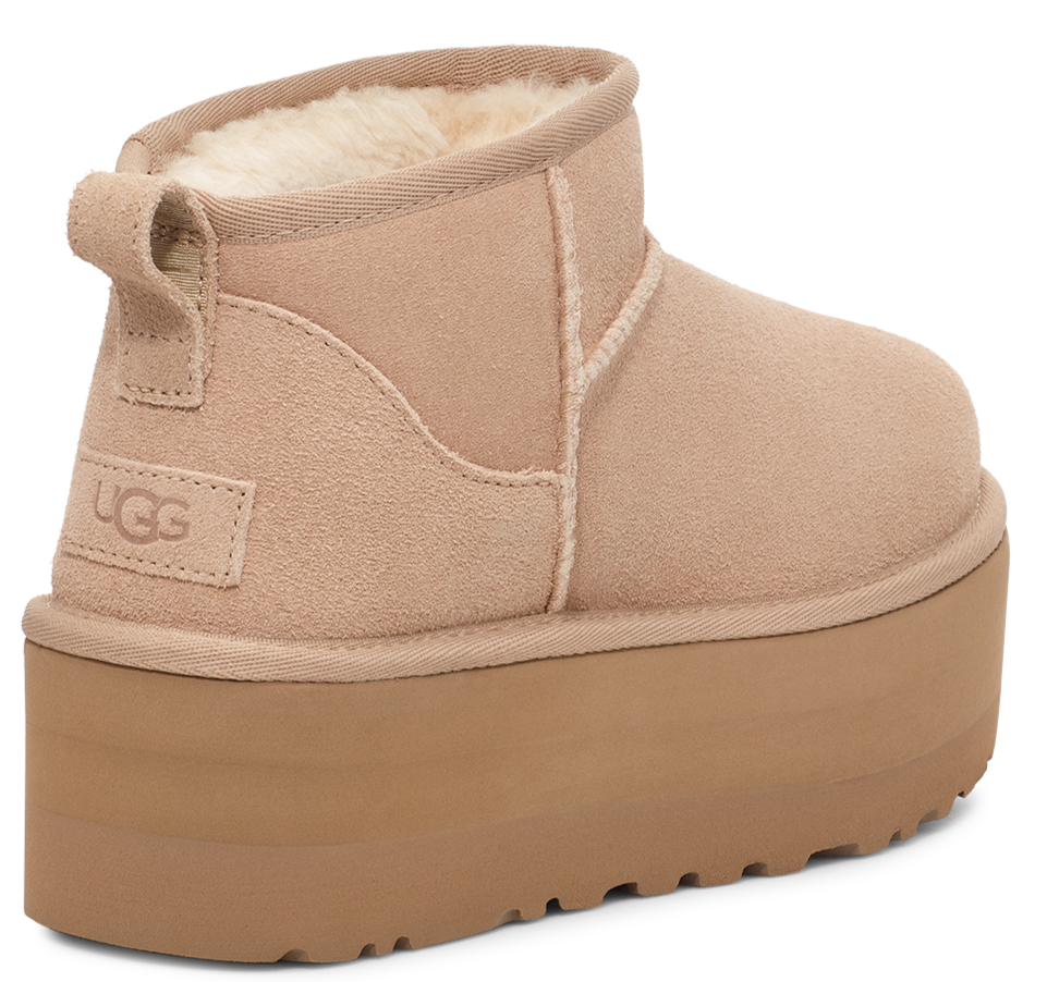 Close up of a light brown suede boot with a light brown platform sole and UGG logo.