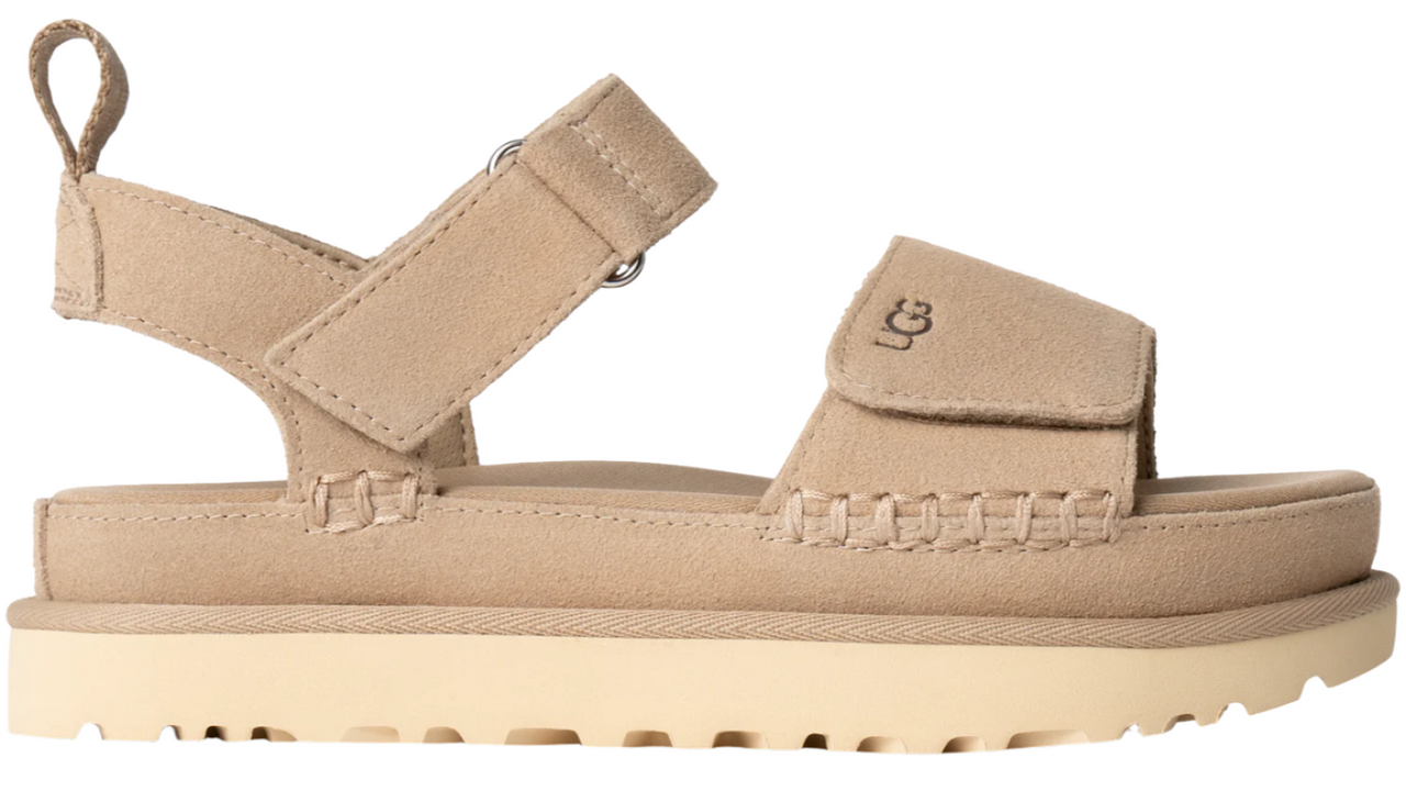 Tan suede sandal with adjustable straps and cream-colored platform sole. The strap above the toe box has the letters "UGG" printed on it.